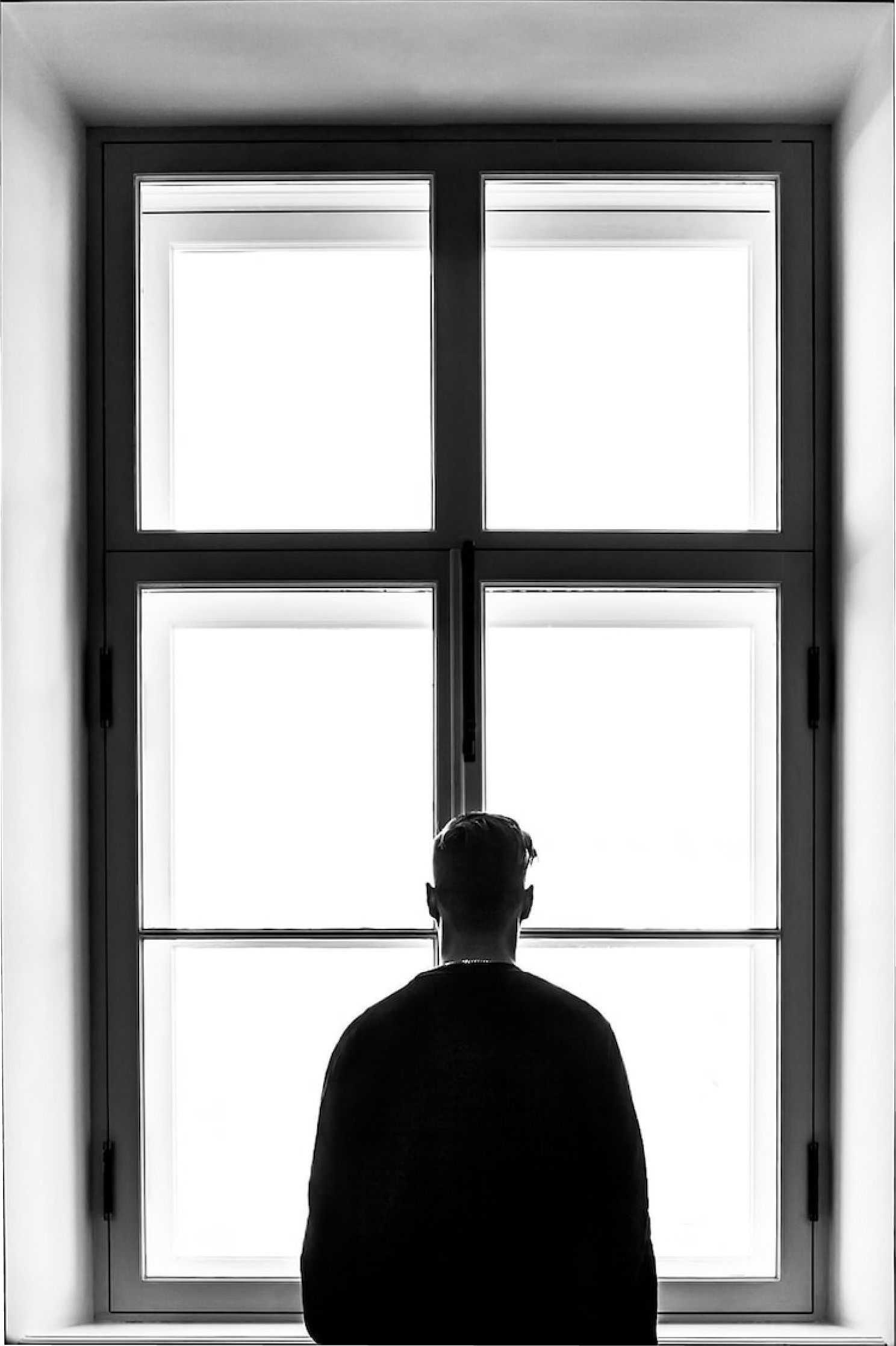 A guy staring out of a window